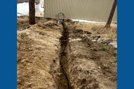 Excavating in Palmer Lake, Colorado running a new electrical line to an outbuilding on a very steep slope