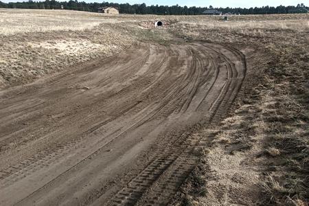 Excavating in Black Forest, Colorado. Grading the outfall of this culvert to insure we have proper grade and that we can install erosion control measures to get the grass to grow.
