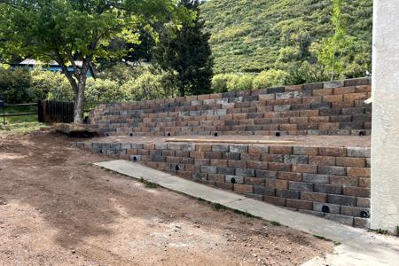 Retaining wall in Palmer Lake, Colorado. Installed a segmental retaining wall in order to level off the area in front of the home for more parking and a concrete hot tub pad