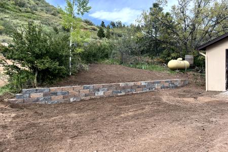 Retaining wall in Palmer Lake, Colorado. Installed a segmental retaining wall in Palmer Lake to level off the propane tank area, increase the parking in front of the home and to divert the water and dirt from falling into the driveway.