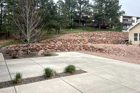Retaining wall Monument, Colorado. Installed a boulder wall to control the flow of water and loose dirt from entering the back yard. This is also erosion control as now we control the flows.